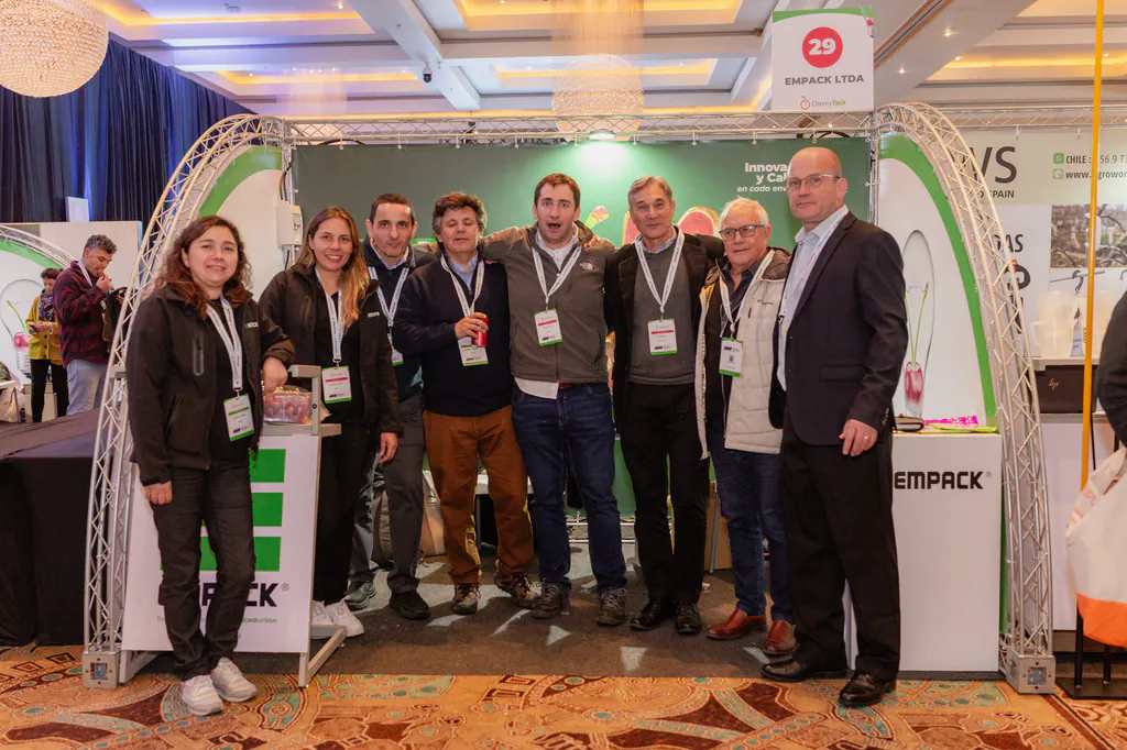 cherry-tech-foto-grupal-stand-monticello-317 equipo de asistentes posando en zona de exhibición del evento de cherry tech
