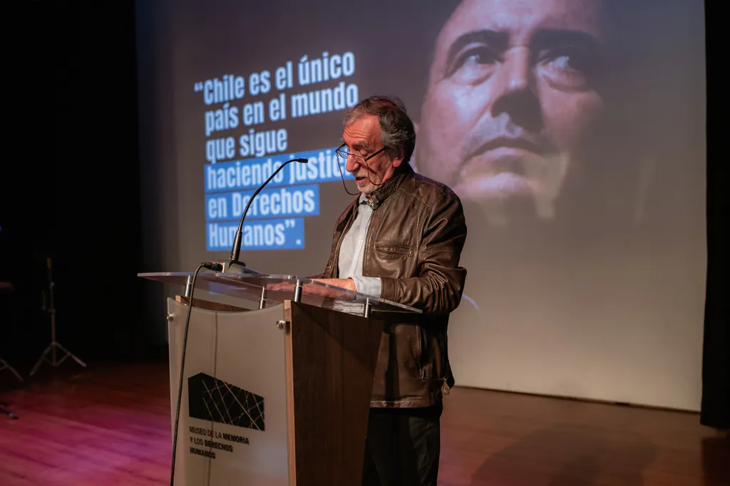 homenaje-nelson-caucoto-discurso-podio-proyeccion-museo-de-la-memoria Discurso frente al público durante evento en el Museo de la Memoria