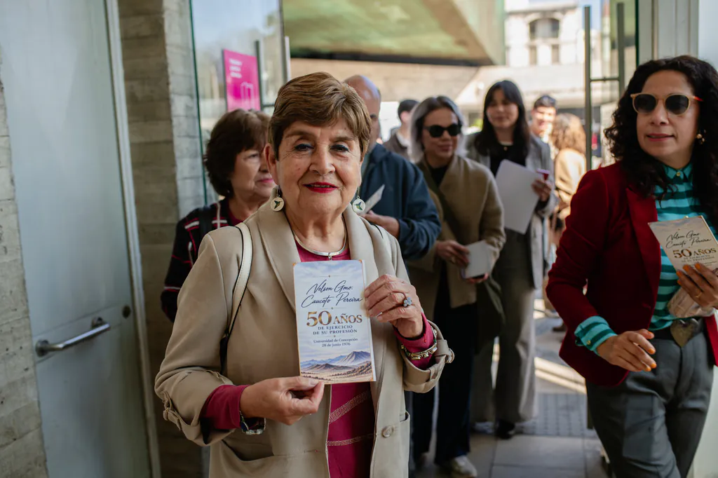 homenaje-nelson-caucoto-invitada-con-programa-museo-de-la-memoria Invitada sosteniendo el programa de la celebración por los 50 años de trayectoria