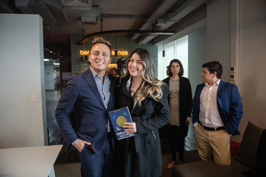insightlabs-retrato-dos-asistentes-con-libro-customertrigger-santiago Asistentes durante jornada corporativa de InsightLab en Santiago