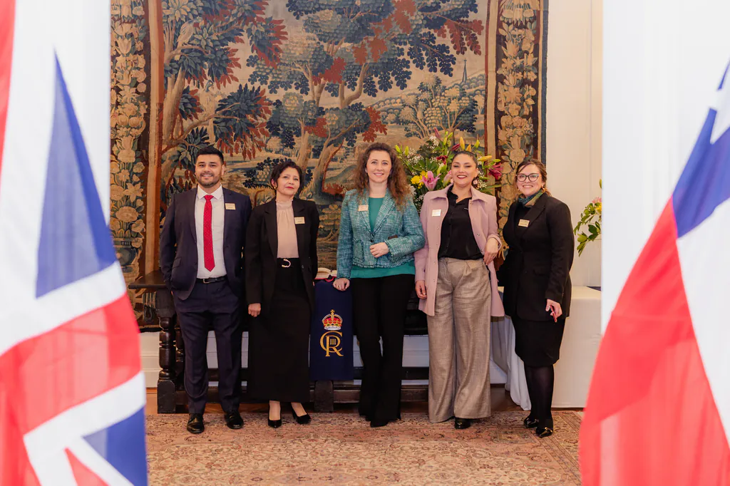 oxford-test-of-english-foto-grupal-entre-banderas-embajada-britanica-santiago grupo de asistentes entre banderas británicas durante evento en la embajada